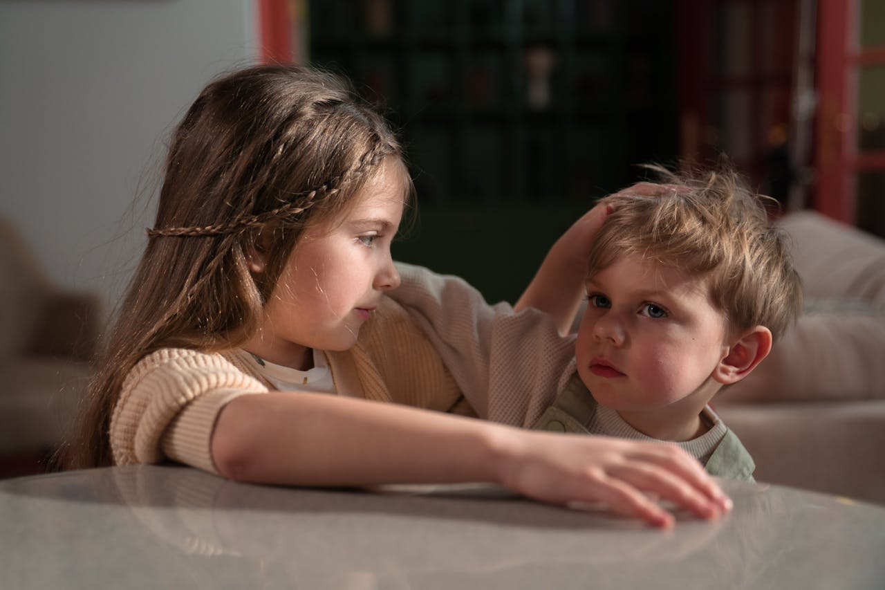 Heartwarming moment of a brother and sister showing affection indoors, embodying sibling love.